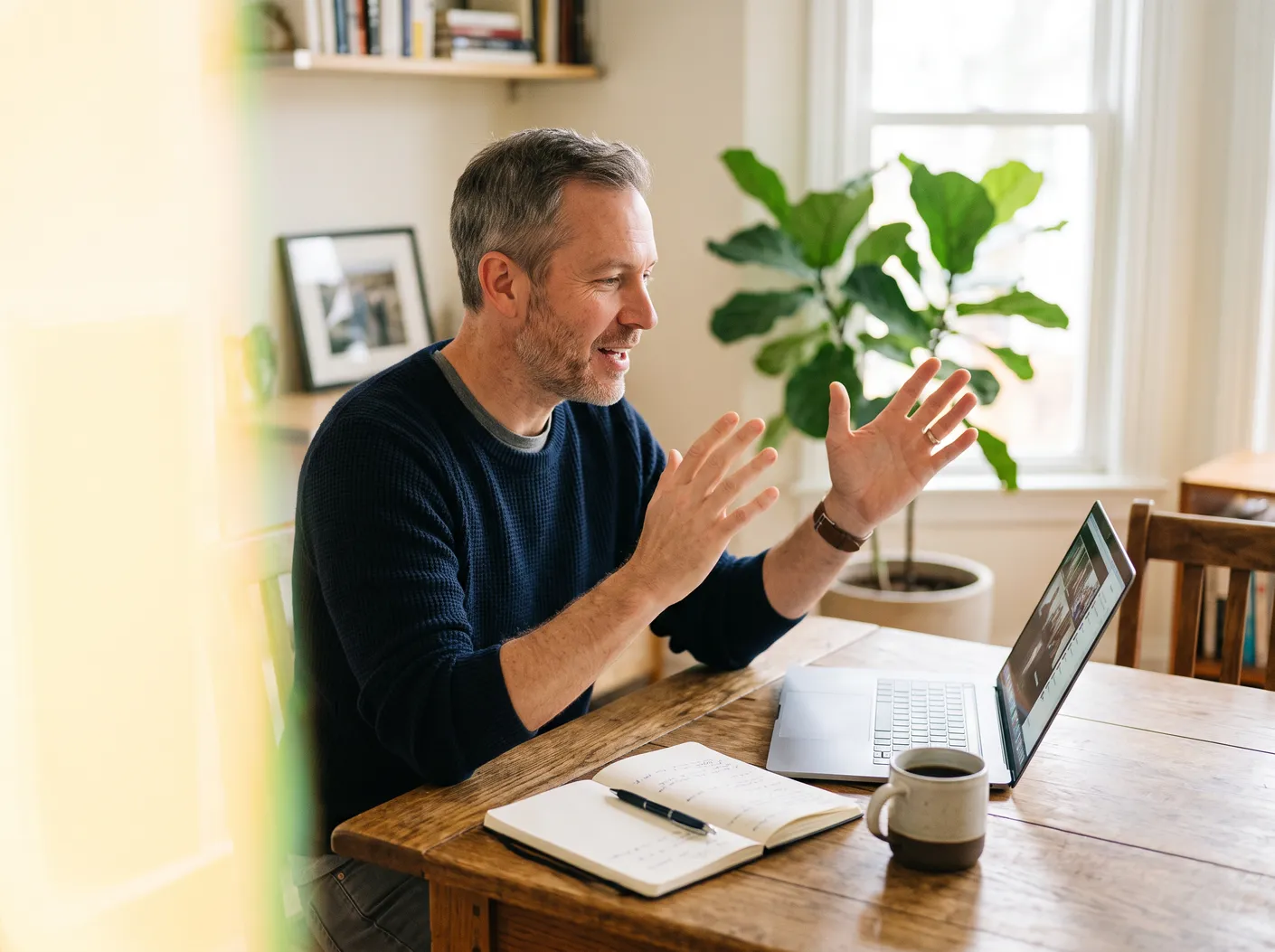 A man at a desk gesturing during an online call – David Zelenka